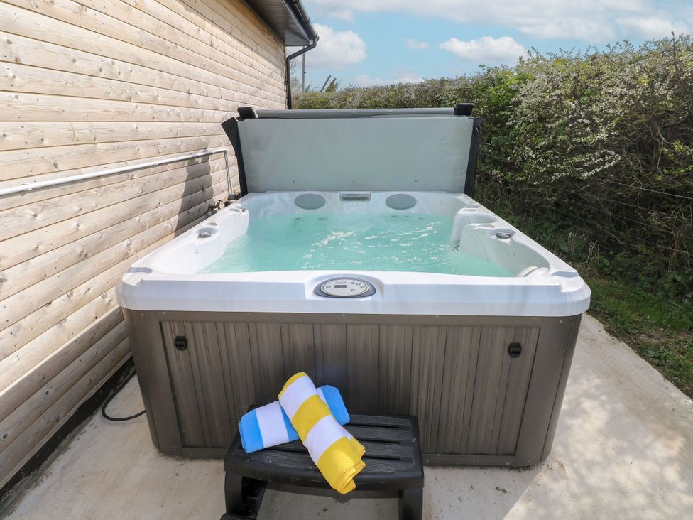 A hot tub with towels on a bench at Monks Rest in Monknash