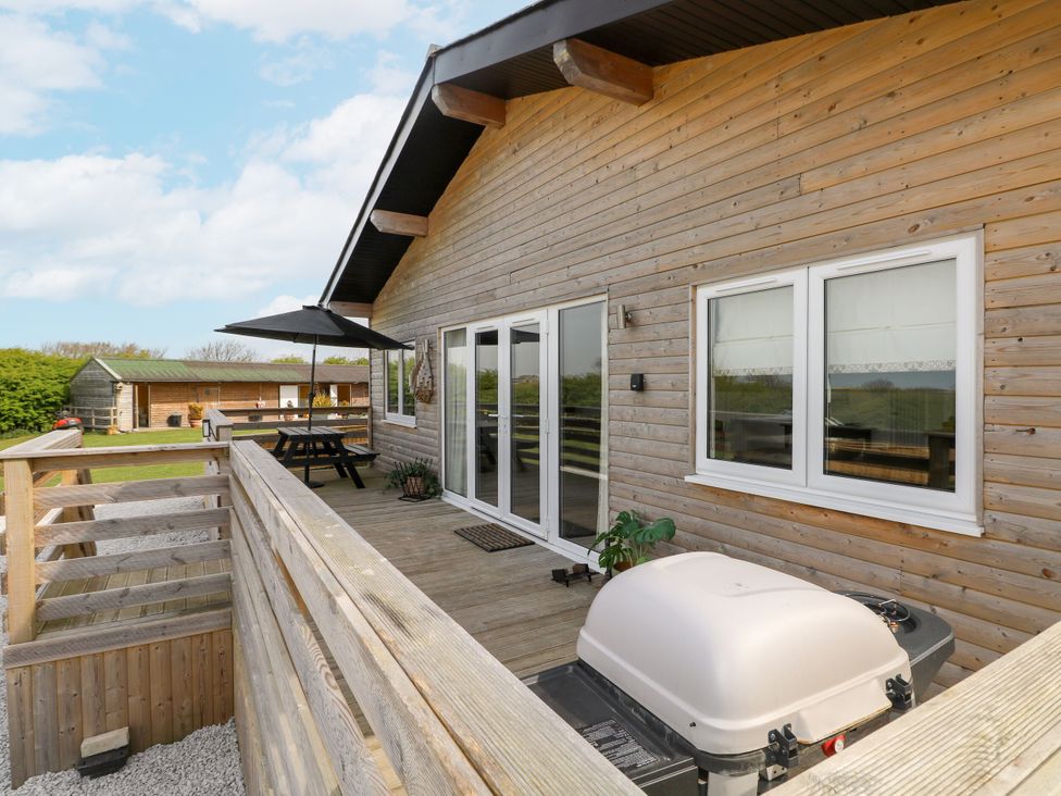 An outdoor area with a table and grill at Monks Rest in Monknash