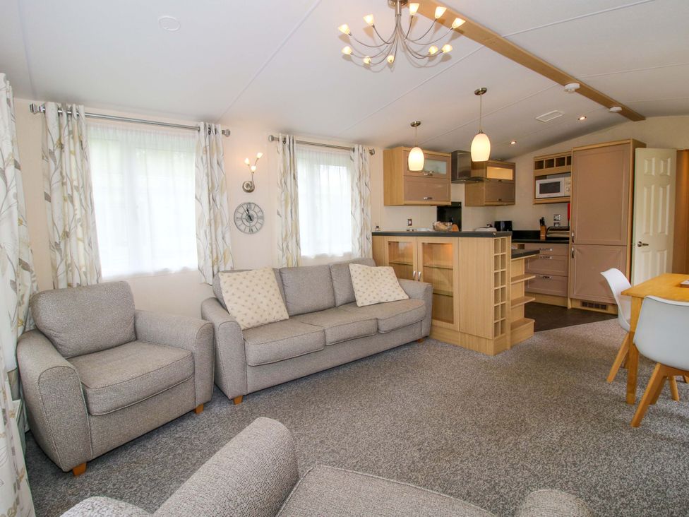 A living room with a sofa and dining area at Dove in Shobdon