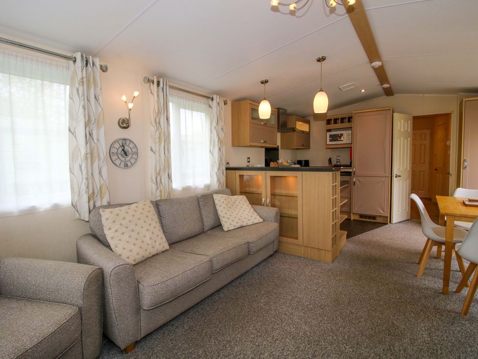 A living room with a sofa and dining area at Dove in Shobdon