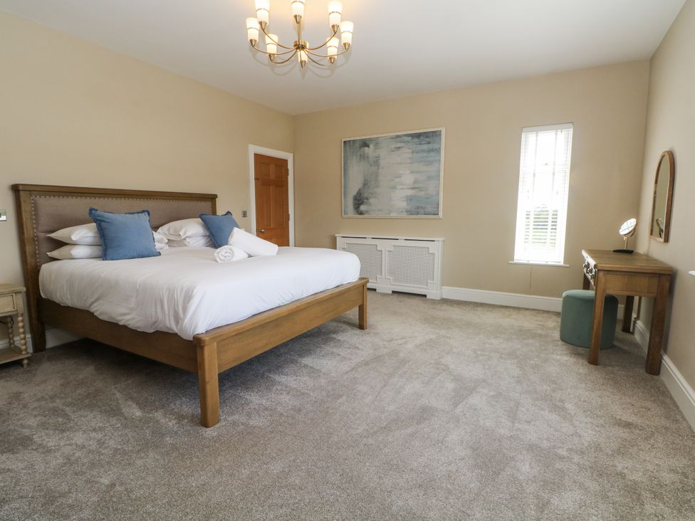 A bedroom with a bed and mirror at Meadow Manor And Spa Prees near Whitchurch