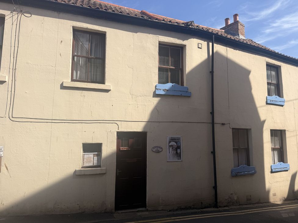 An exterior view of a building with windows and a door at Hideaway Cottage in Whitby