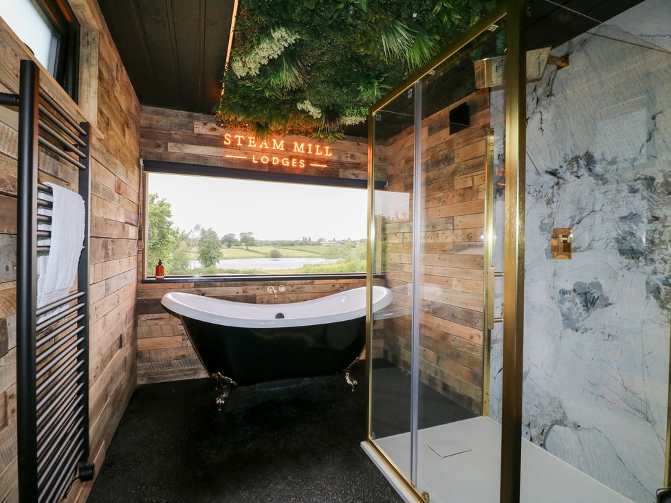 A bathroom with a bathtub and shower at Steam Mill Lodges in Oakthorpe near Donisthorpe