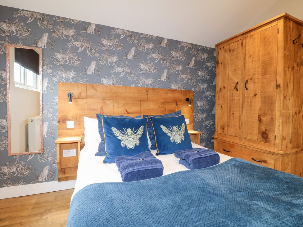A bedroom with a bed and wooden furniture at Birch in Oakthorpe near Donisthorpe