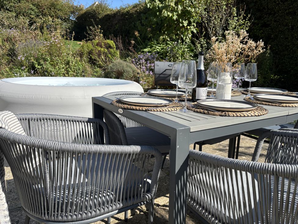 An outdoor dining area with a table and chairs at Topsails in Totland Bay