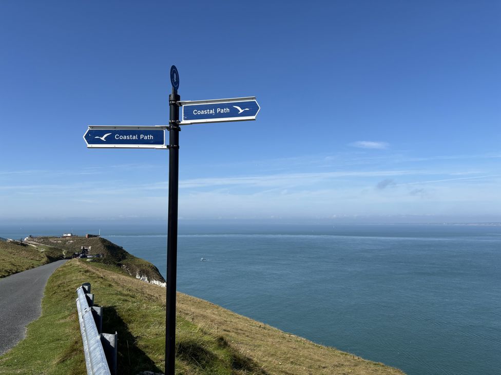 A signpost for Coastal Path over the ocean at Topsails in Totland Bay