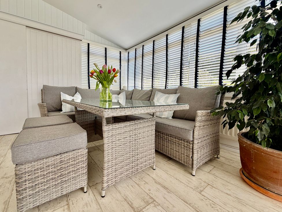 A conservatory with sofa and coffee table at Topsails in Totland Bay