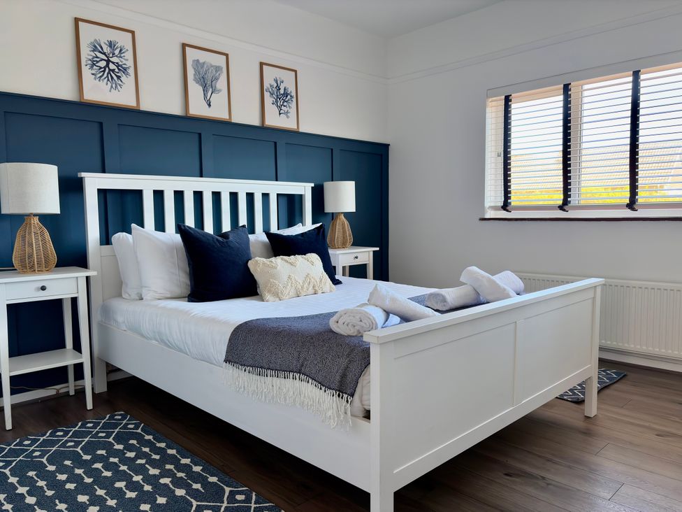 A bedroom with a bed and nightstands at Topsails in Totland Bay