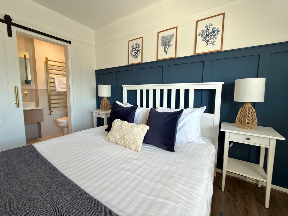 A bedroom with a bed and nightstands at Topsails in Totland Bay