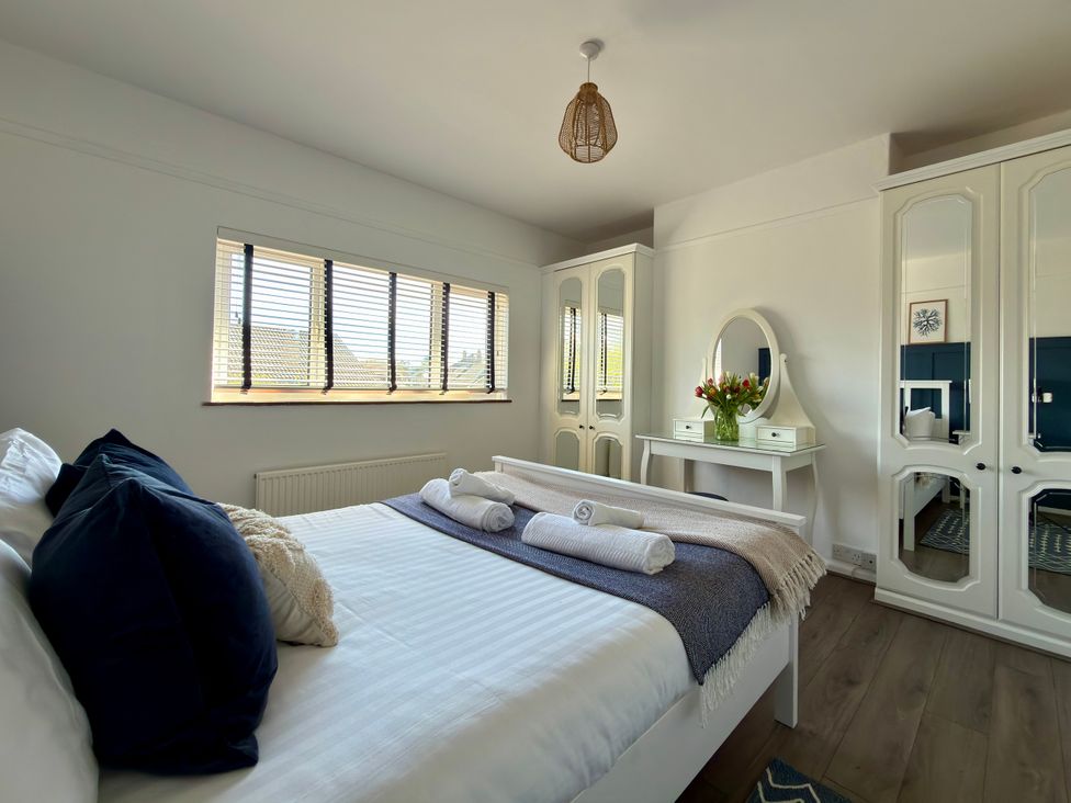A bedroom with a bed and a dresser at Topsails in Totland Bay