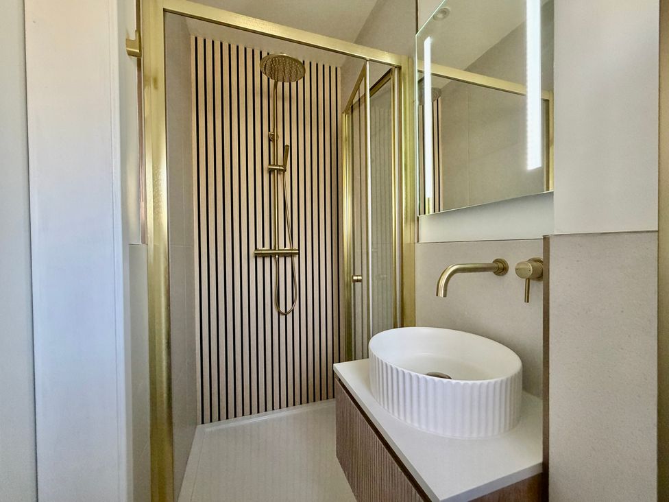 A bathroom with a shower and sink at Topsails in Totland Bay