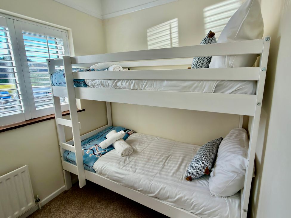 A bunk bed with towels on the lower bed at Topsails in Totland Bay