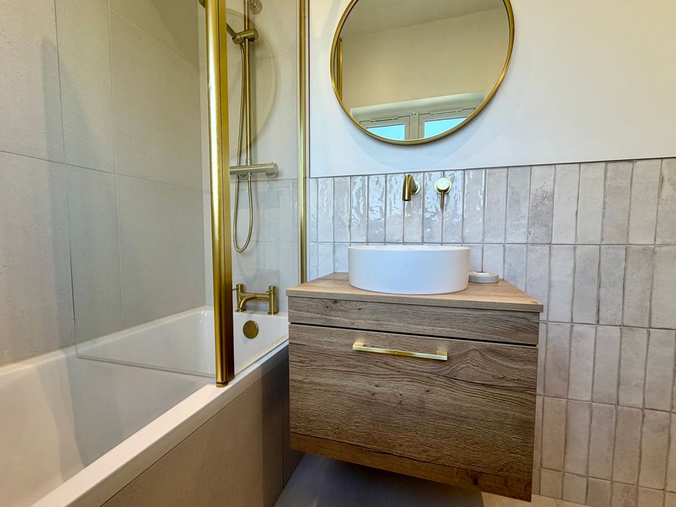 A bathroom with a sink and bathtub at Topsails in Totland Bay