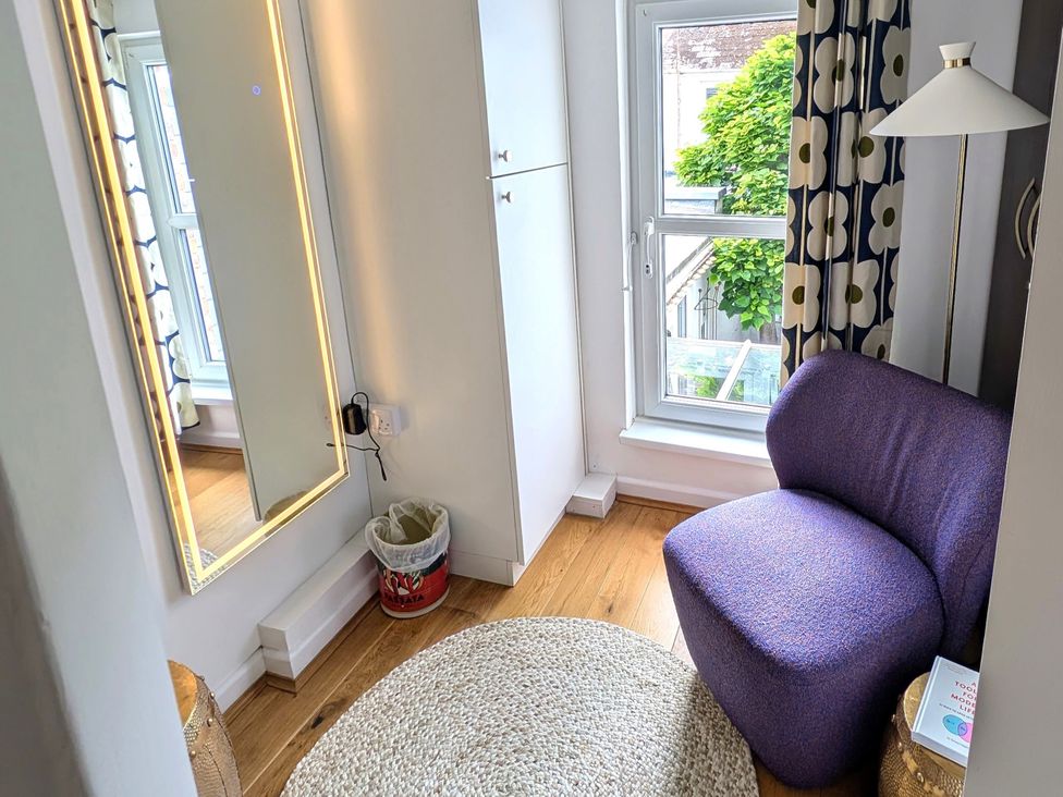A room with a purple chair and a mirror at Harbour Retreat in Weymouth