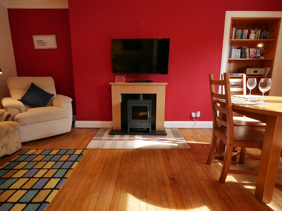 A living room with a television and fireplace at Seal Cottage in Eyemouth