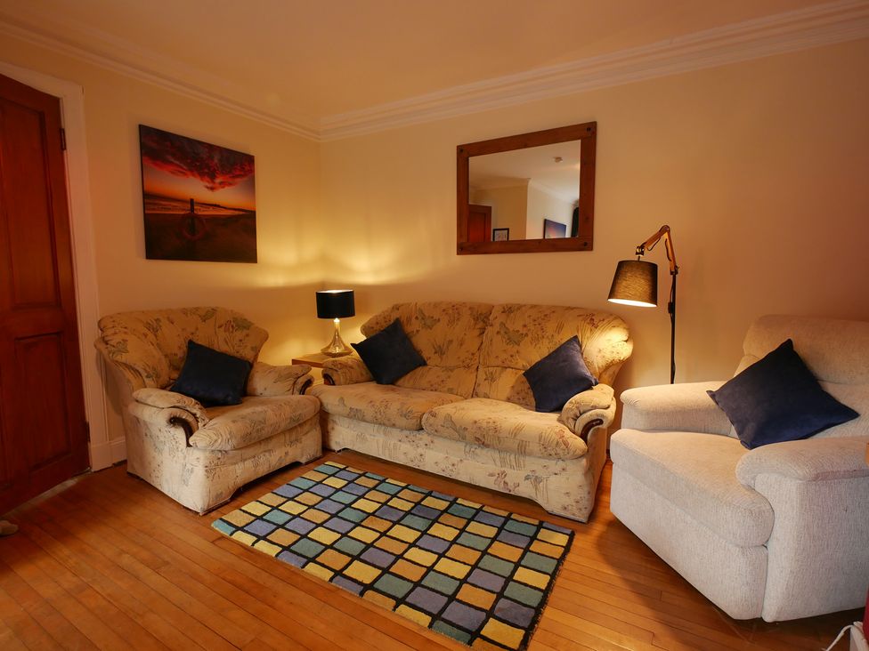 A living room with a sofa and armchair at Seal Cottage in Eyemouth