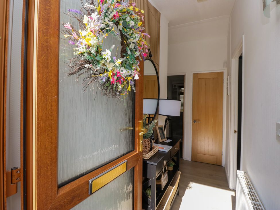 A hallway with a console table and lamp at Ruskin Lodge, Langdale 16, White Cross Bay near Windermere