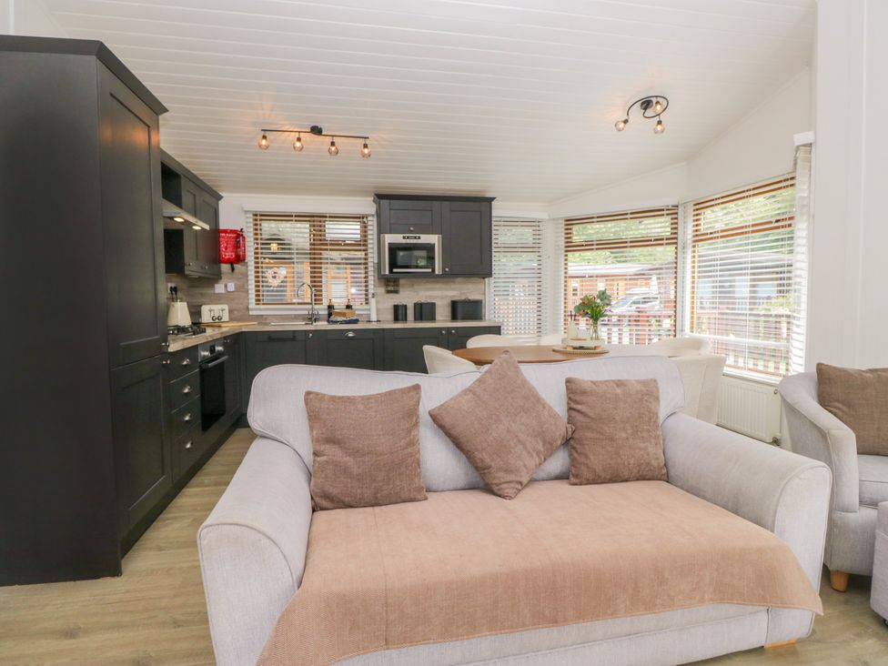 A kitchen with dining area and sofa at Ruskin Lodge in Langdale 16, White Cross Bay near Windermere