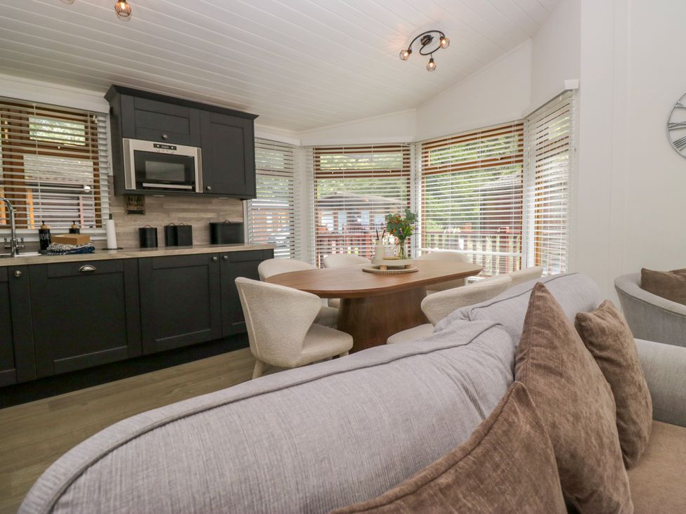 A kitchen with a dining table and chairs at Ruskin Lodge Langdale 16, White Cross Bay near Windermere