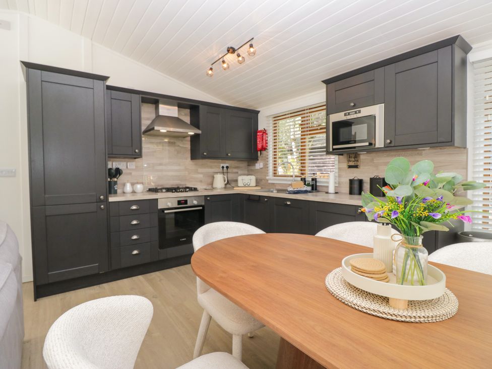 A kitchen with cabinets and appliances at Ruskin Lodge Langdale 16, White Cross Bay near Windermere
