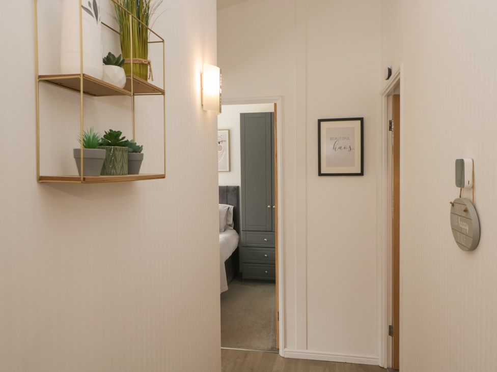 A hallway view with a shelf and door at Ruskin Lodge Langdale 16 White Cross Bay near Windermere