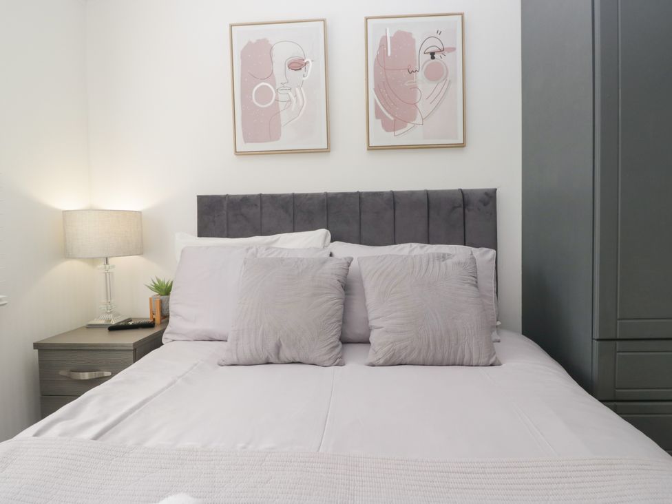 A bedroom with a bed and artwork at Ruskin Lodge, Langdale 16, White Cross Bay near Windermere
