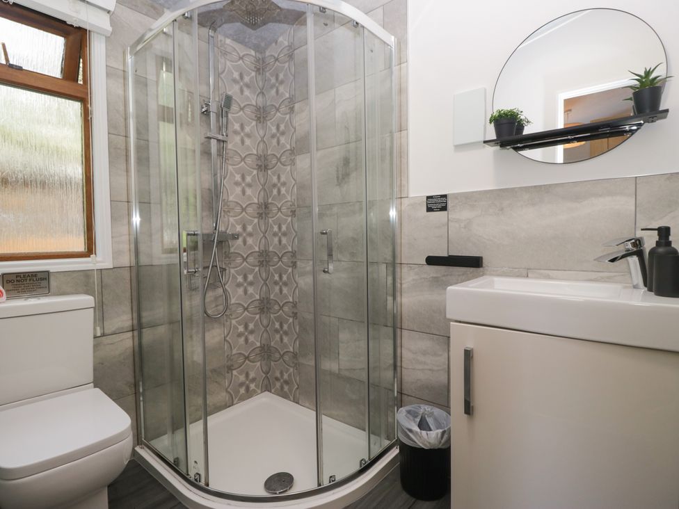 A bathroom with a shower, toilet, and sink at Ruskin Lodge, Langdale 16, White Cross Bay near Windermere
