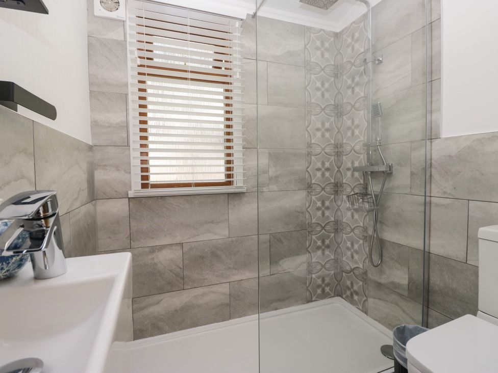 A bathroom featuring a shower, toilet, and sink at Ruskin Lodge, Langdale 16, White Cross Bay near Windermere