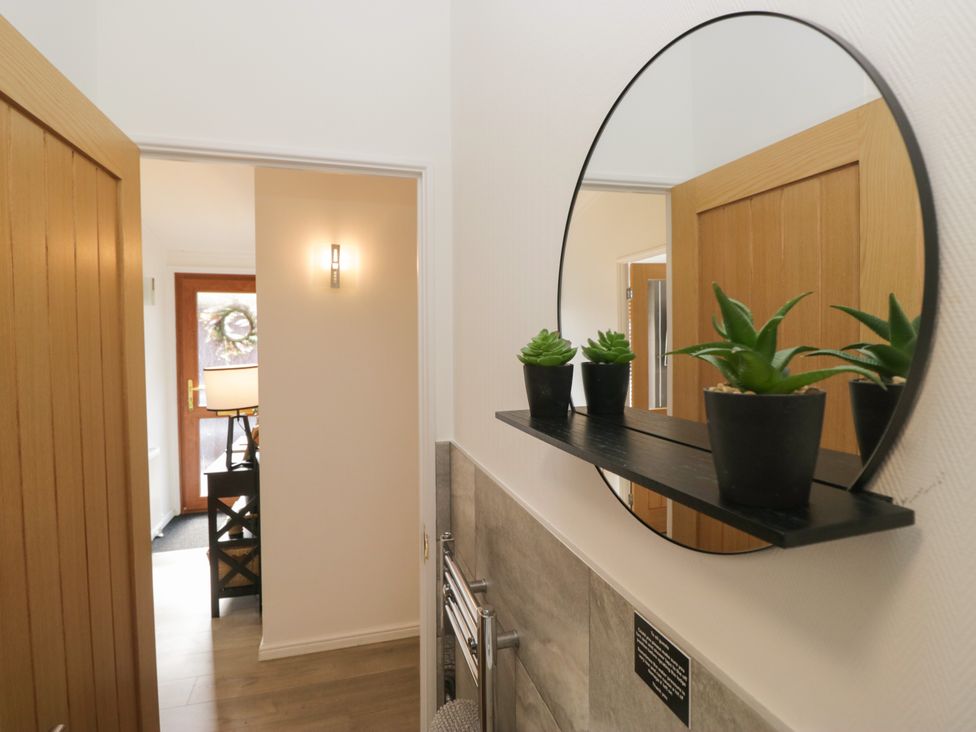 A hallway with a mirror and plants at Ruskin Lodge, Langdale 16, White Cross Bay near Windermere