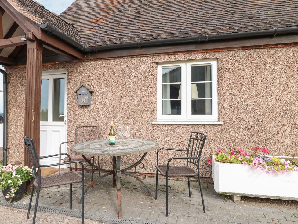 An outdoor seating area with a table and chairs at The Hereford Lodge in Great Haywood