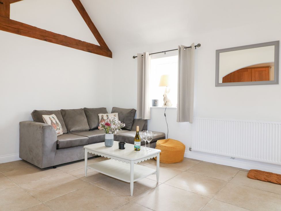 A living room with a sofa, table, and glassware at The Hereford Lodge in Great Haywood