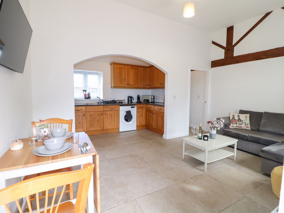 A living room with kitchen area and dining table at The Hereford Lodge in Great Haywood