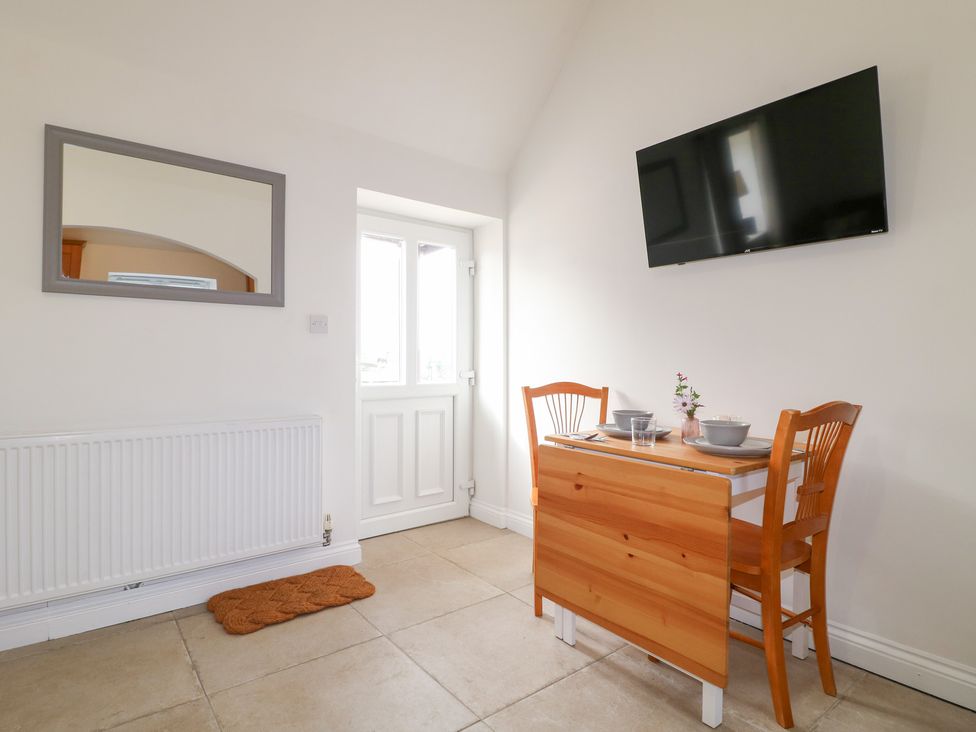 A dining area with a table and chairs at The Hereford Lodge in Great Haywood
