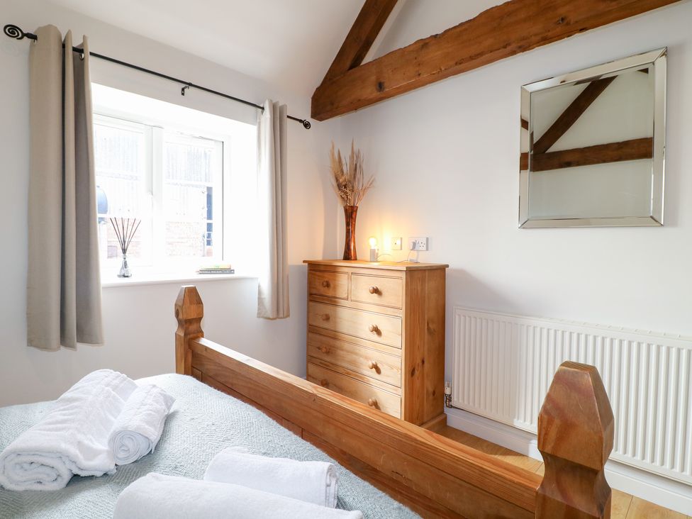 A bedroom with a bed and dresser at The Hereford Lodge in Great Haywood