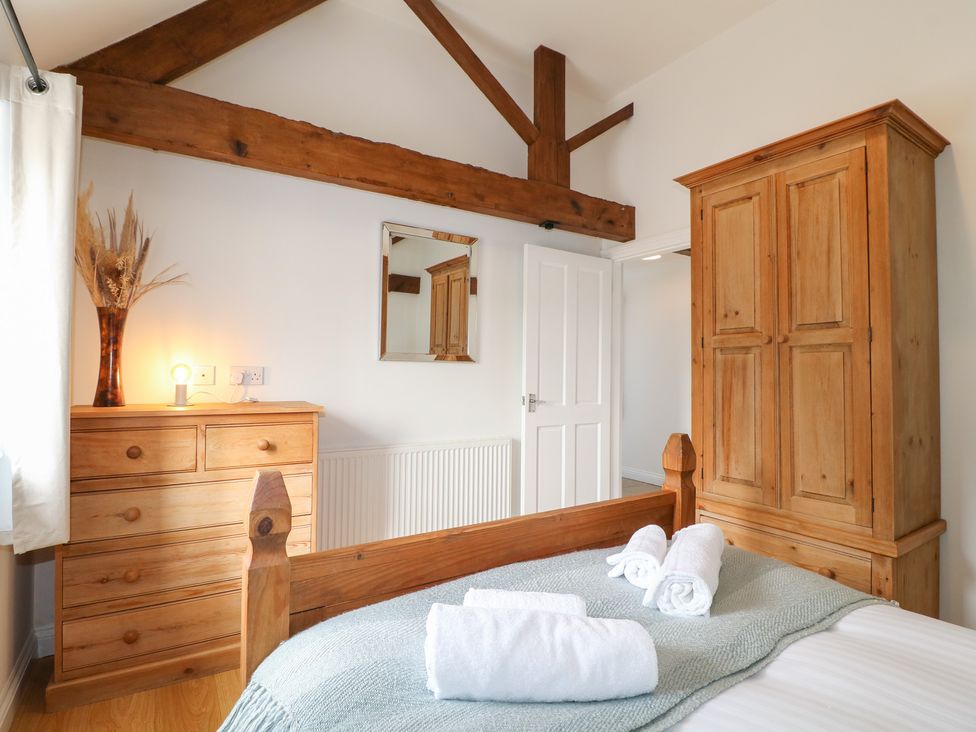 A bedroom with a bed and wooden furniture at The Hereford Lodge in Great Haywood