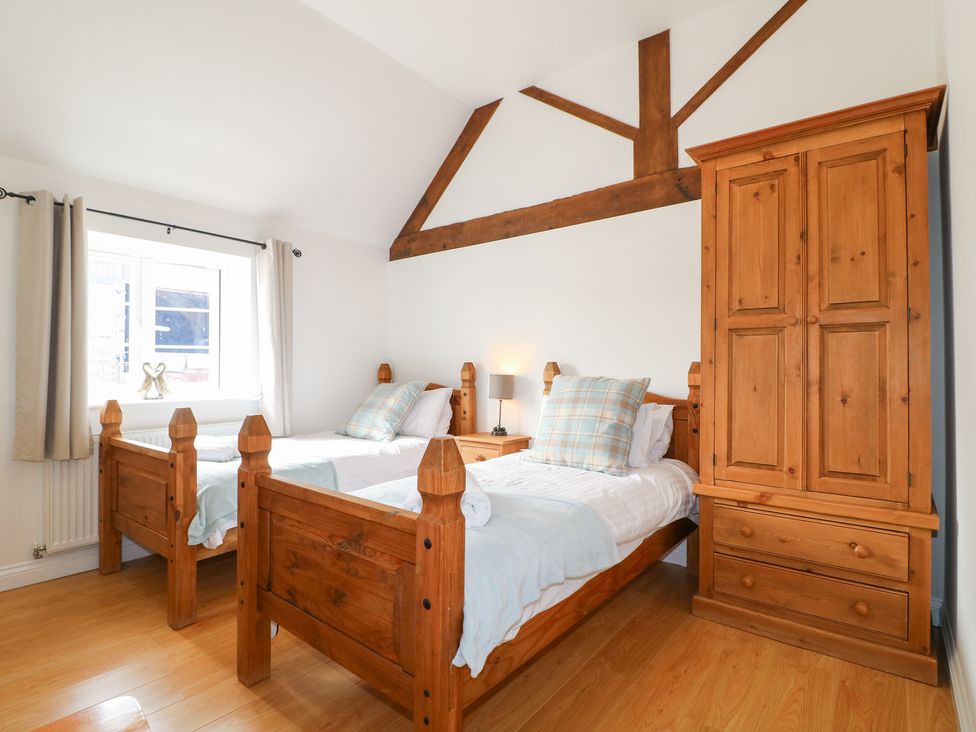 A bedroom with two beds and a wardrobe at The Hereford Lodge in Great Haywood
