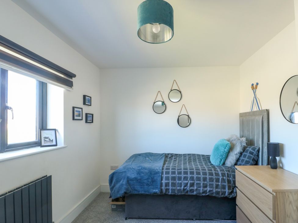 A bedroom with a bed and nightstand at Iscoed in Rhosneigr
