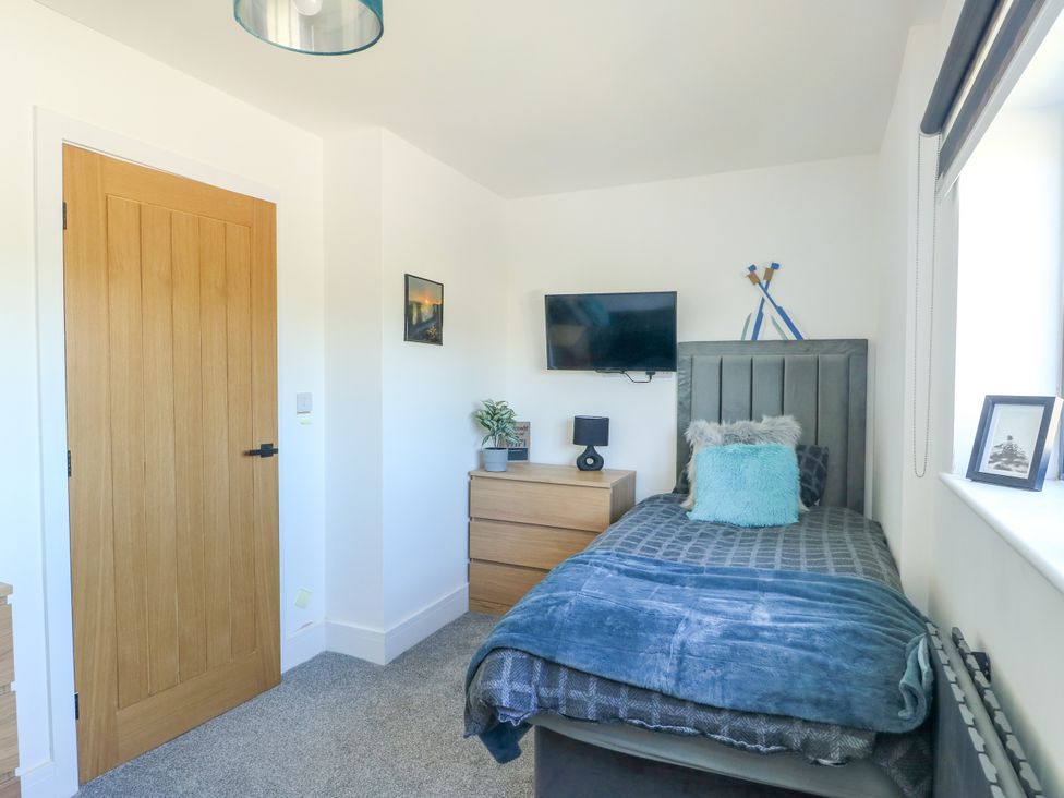 A bedroom with a single bed and television at Iscoed Rhosneigr