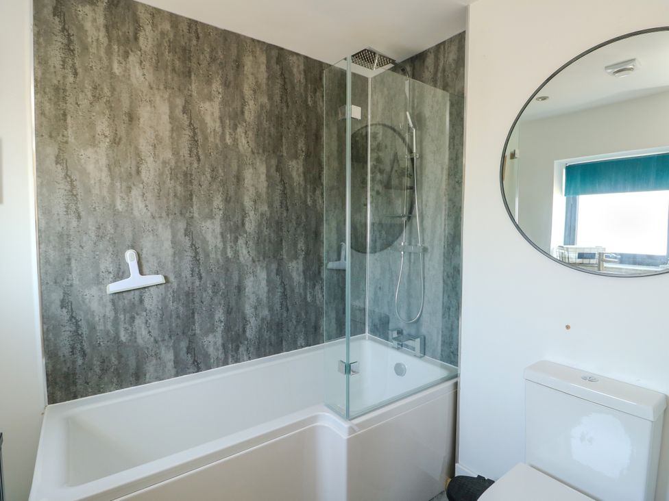 A bathroom featuring a bathtub and shower at Iscoed in Rhosneigr