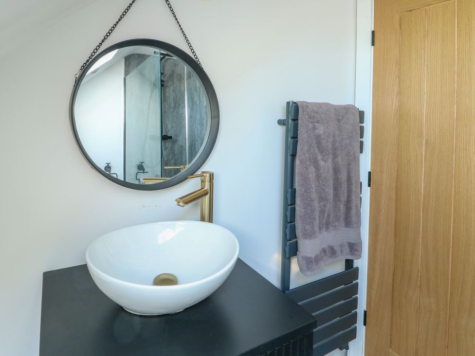 A bathroom with a sink and mirror at Iscoed Rhosneigr