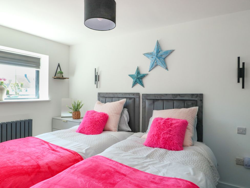 A bedroom with two beds and decorative stars at Iscoed in Rhosneigr