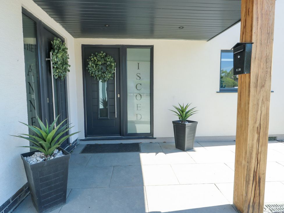 An entrance with a black door and planters at Iscoed Rhosneigr