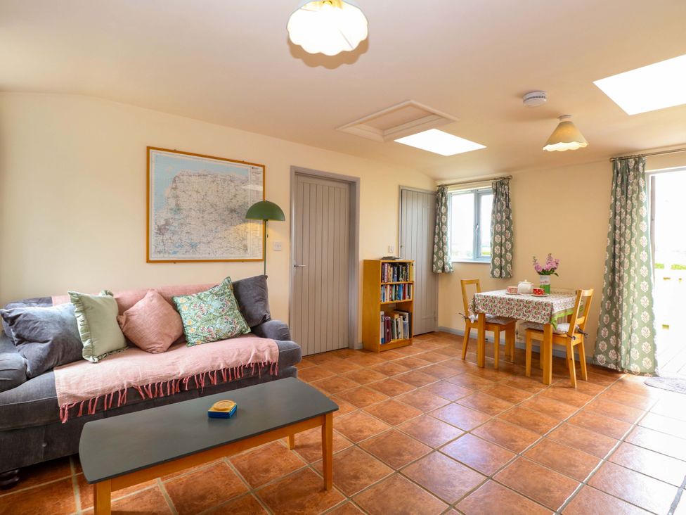 A living room with a sofa and table at Foxglove in King's Lynn
