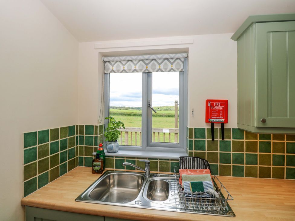 A kitchen with a sink and window at Foxglove in King's Lynn