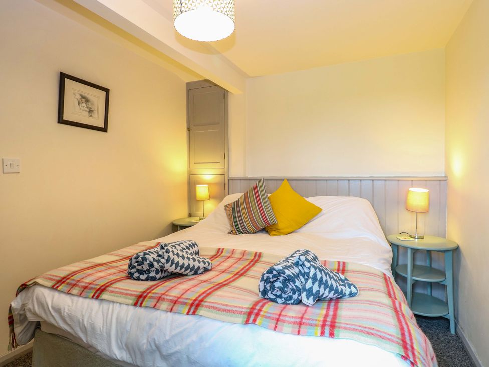 A bedroom with a bed and nightstands at Foxglove in King's Lynn