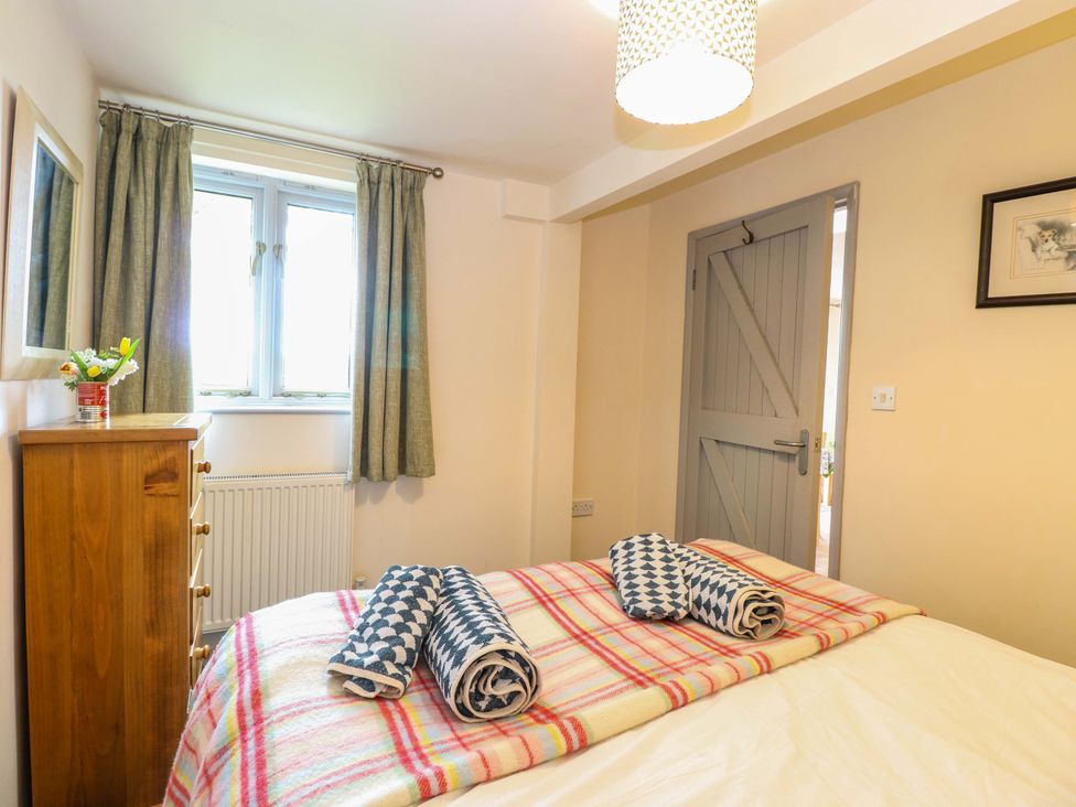 A bedroom with a bed and dresser at Foxglove in King's Lynn
