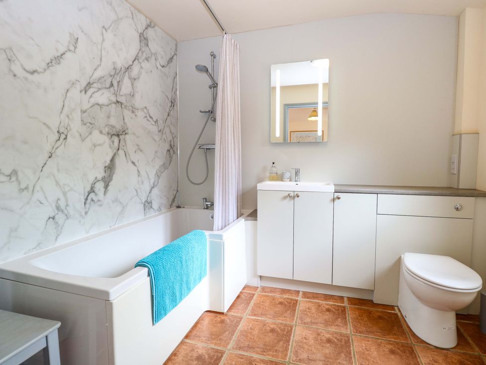 A bathroom with a bathtub and sink at Foxglove in King's Lynn