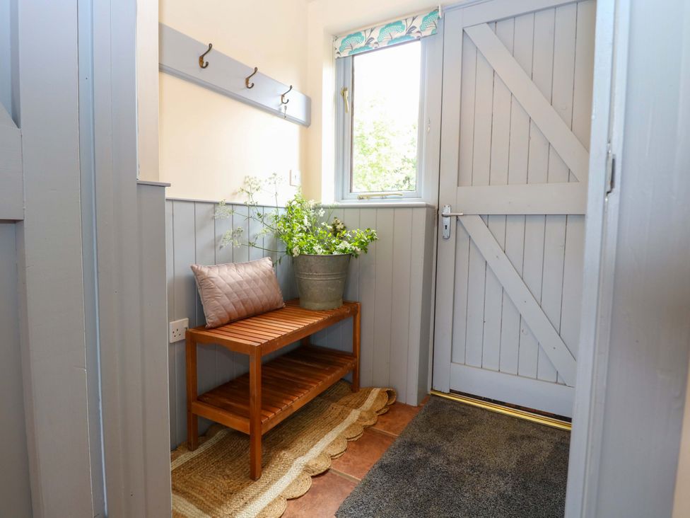 A hallway with a bench and plant at Foxglove in King's Lynn