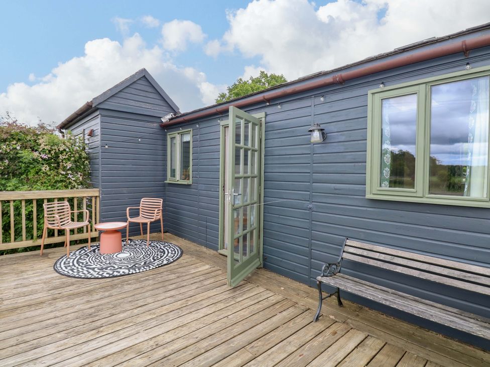 An outdoor deck area with seating and a table at Foxglove in King's Lynn
