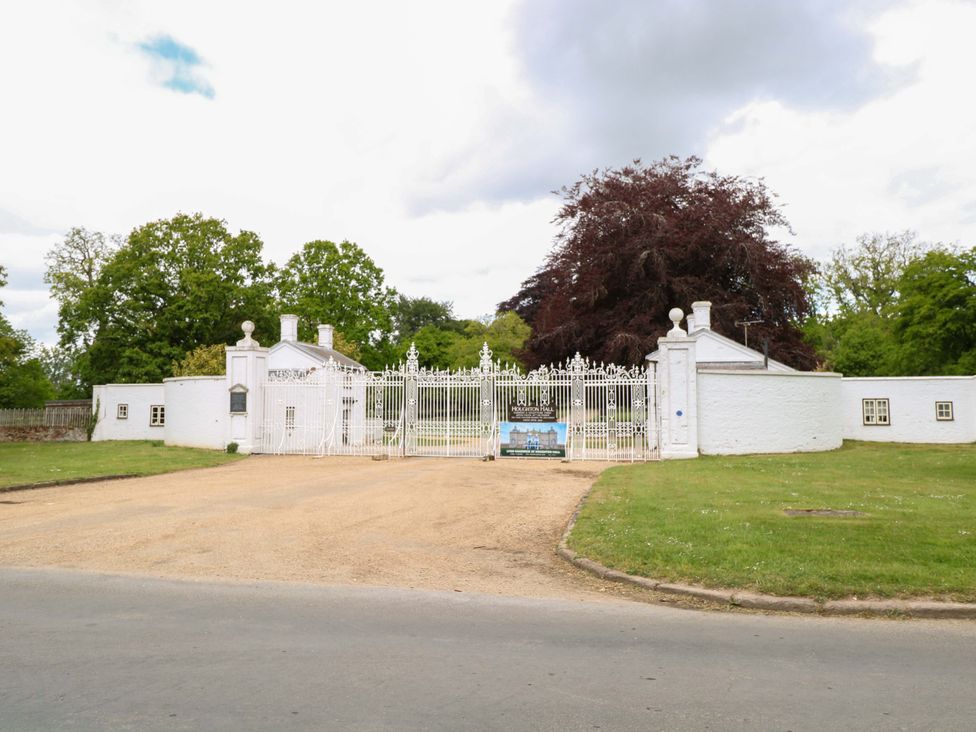 A gated entrance with a building and trees at Foxglove in King's Lynn